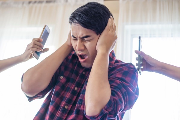 Young man blocking his ears